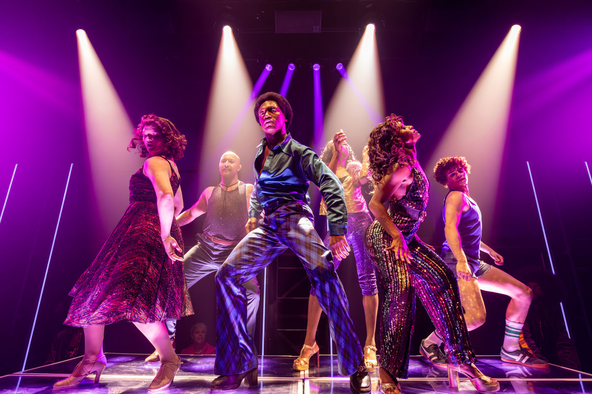Discoshow cast performing on stage in Las Vegas.